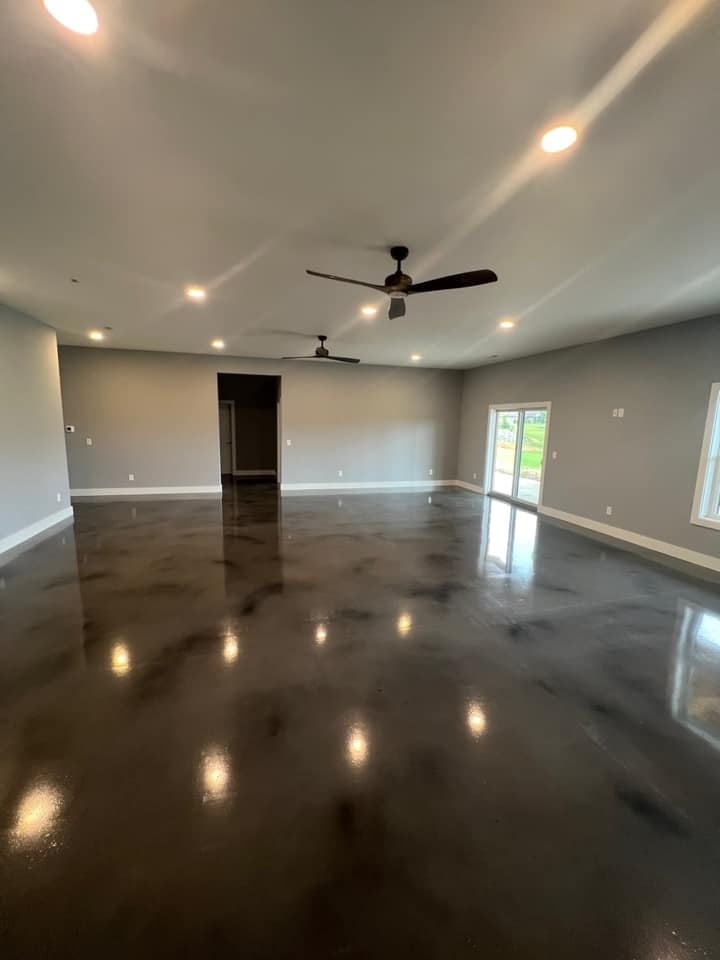 Large living space with polished concrete floors and ceiling fans in a custom home by Debuty Builders, Knoxville, TN