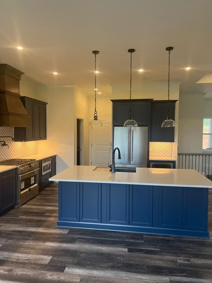 Modern kitchen with blue island and pendant lighting in a custom home by Debuty Builders, Knoxville, TN