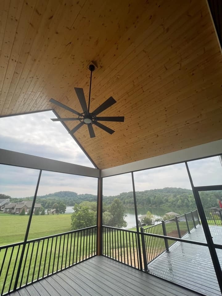 Screened-in porch with wooden ceiling and ceiling fan overlooking a lake, built by Debuty Builders in Knoxville, TN