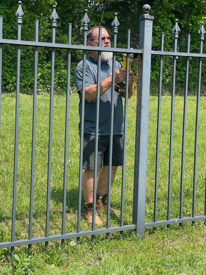 Worker using power tools to install or repair a fence in a residential area by Debuty Builders, Knoxville, TN