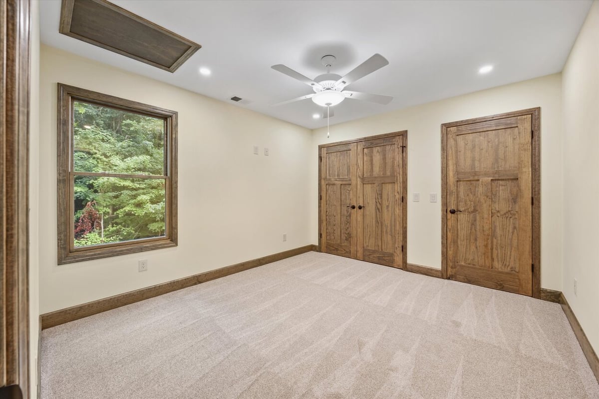 Bedroom with double closets and ceiling fan in Friendsville Custom Home in Knoxville, TN