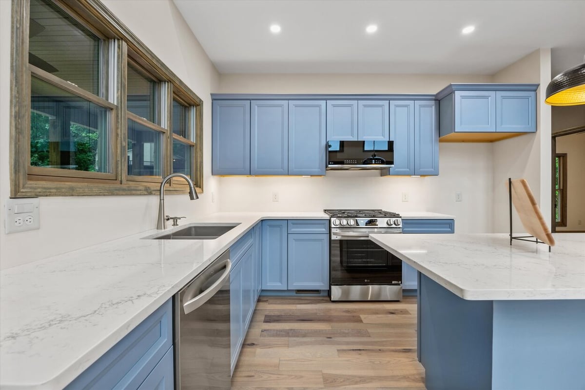 Kitchen with blue cabinetry and marble countertops in Friendsville Custom Home in Knoxville, TN