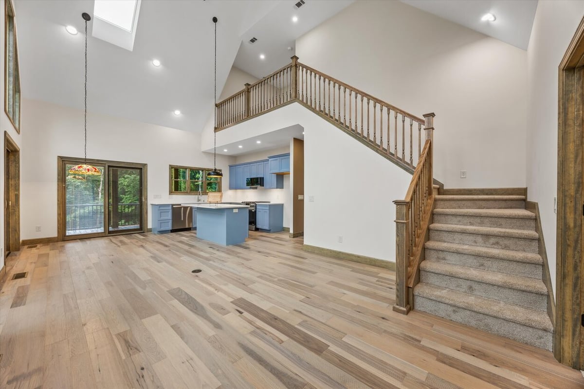 Spacious great room with light hardwood floors and sliding glass doors in Friendsville Custom Home in Knoxville, TN