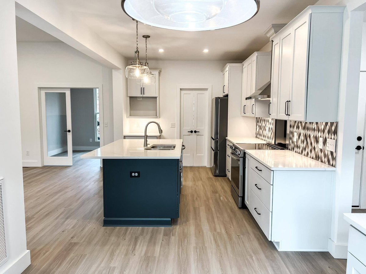 Modern kitchen with shaker-style cabinets, stainless steel appliances, and geometric tile backsplash in a custom home in Knoxville, TN by Debuty Builders, Inc.