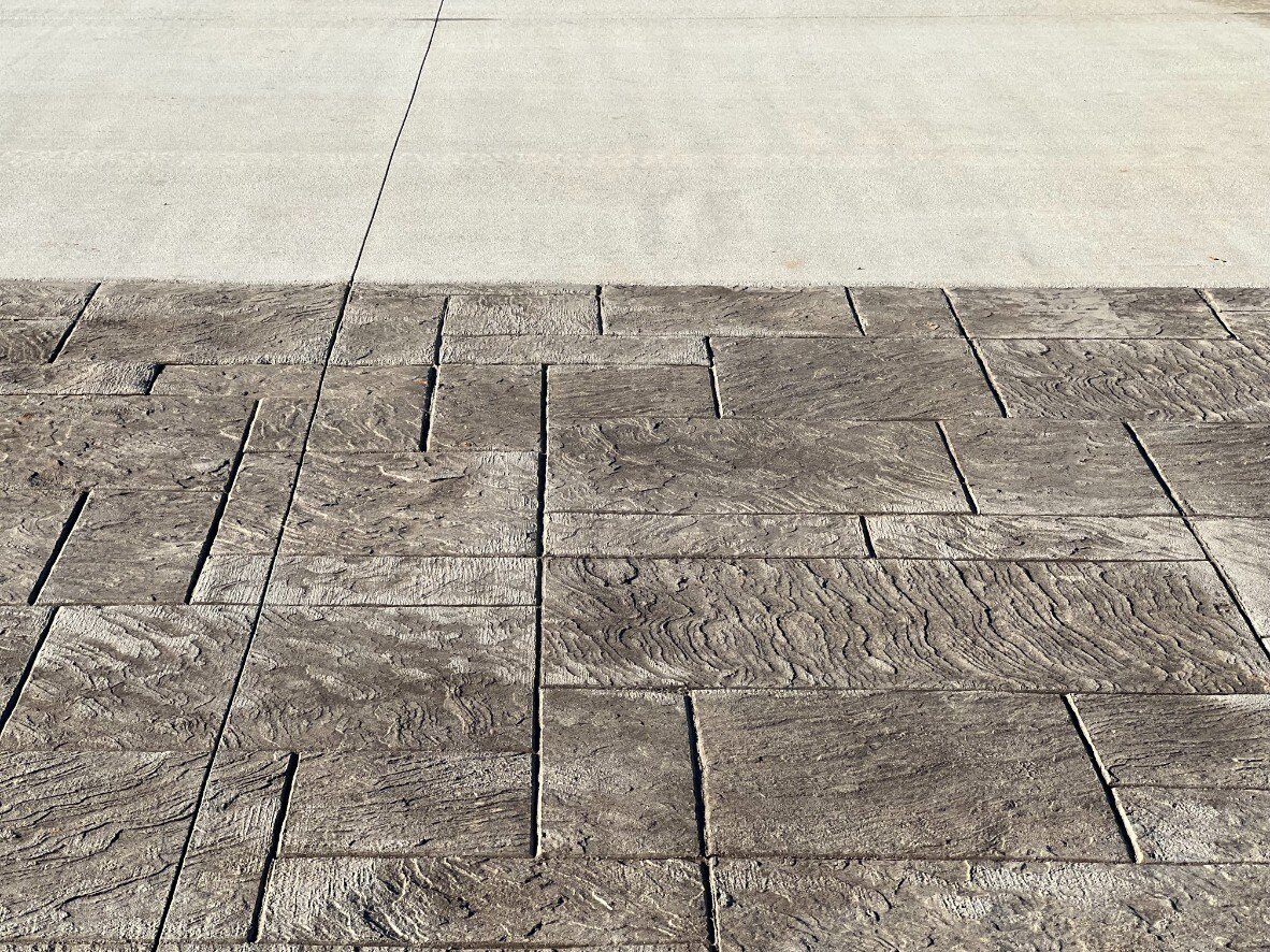 Close-up of the stamped concrete pattern on the driveway of a custom home by Debuty Builders, Inc. in Maryville, TN, showcasing a natural stone texture for enhanced curb appeal