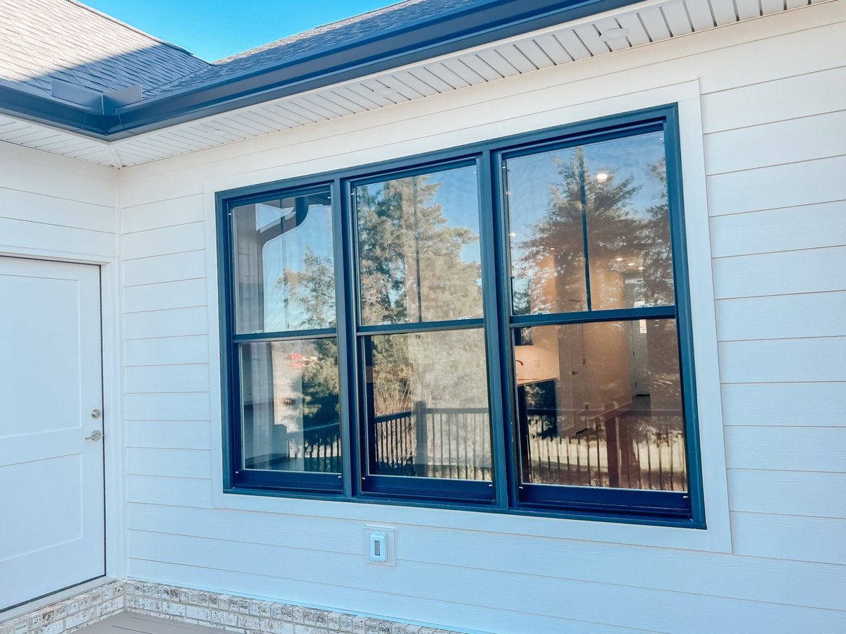 Exterior window view of a custom home by Debuty Builders, Inc. in Maryville, TN, showing black-trimmed windows against white siding