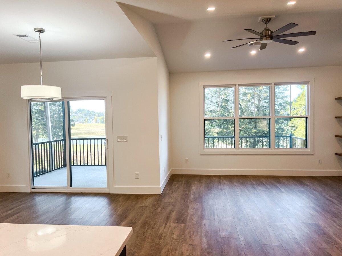 Open-concept dining area in a custom home by Debuty Builders, Inc. in Maryville, TN, with views of a backyard through sliding glass doors leading to a patio