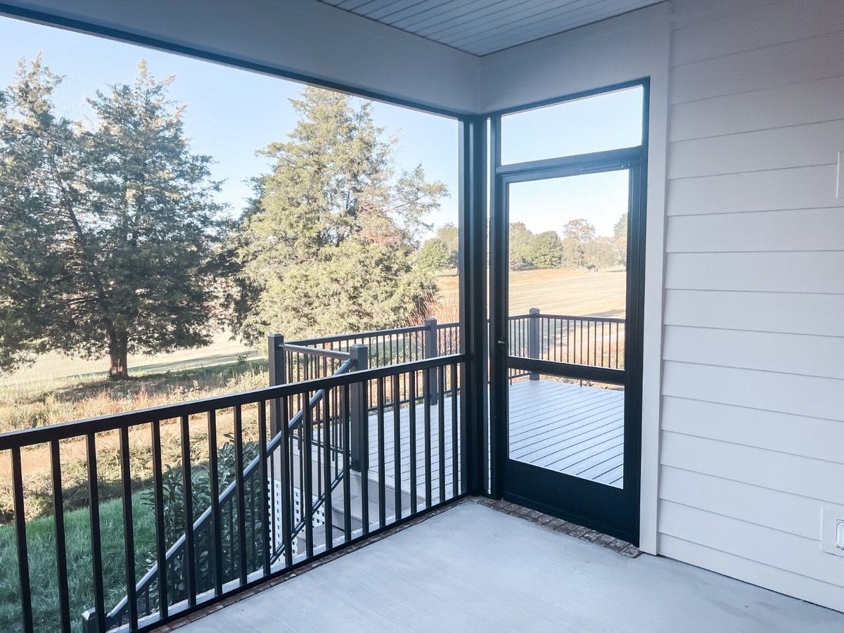 Screened-in patio area in a custom home by Debuty Builders, Inc. in Maryville, TN, overlooking a scenic backyard with lush trees and landscaping