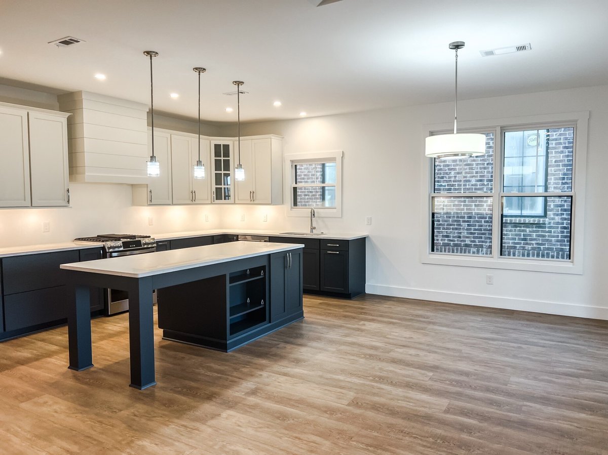 Spacious dining area with natural lighting in a custom home by Debuty Builders, Inc. in Maryville, TN, featuring sliding glass doors and a pendant light