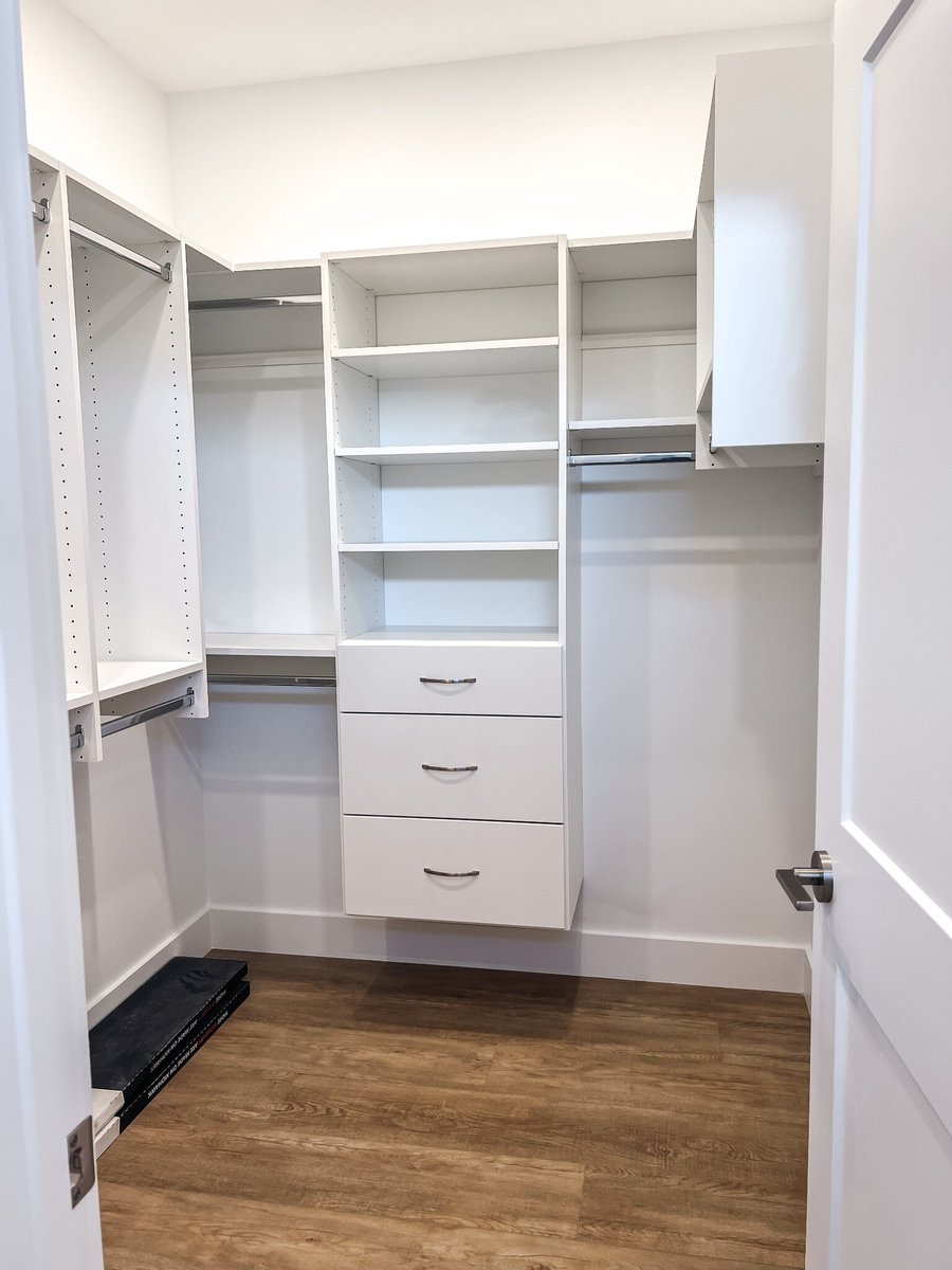 Spacious walk-in closet in a custom home by Debuty Builders, Inc. in Maryville, TN, with built-in shelving, drawers, and hanging space for organized storage