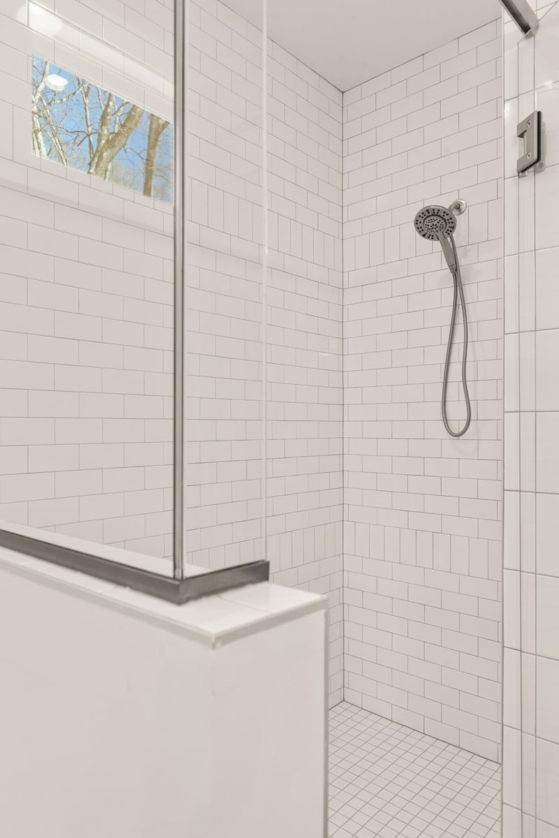Modern white subway tile shower with handheld fixture in Vonore custom home in Knoxville, TN